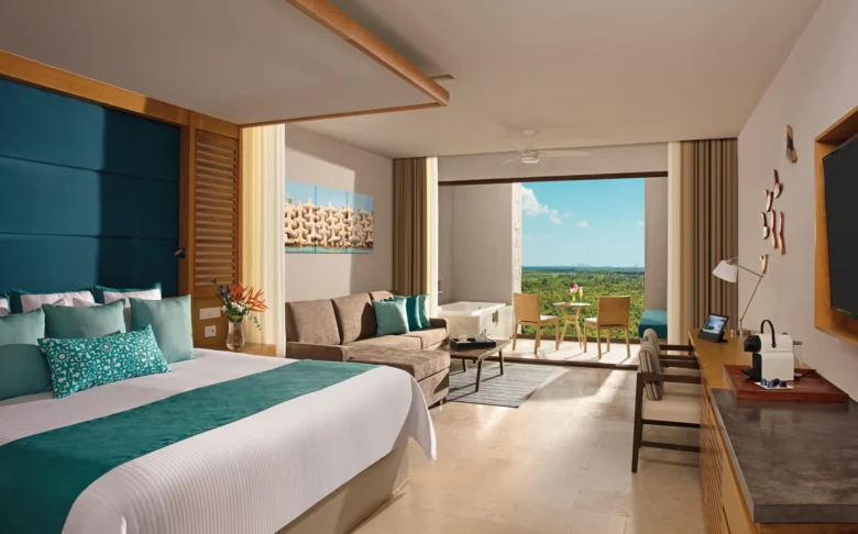 Junior Suite Garden View with king bed, sofa, and terrace with hot tub at Dreams Playa Mujeres Golf & Spa Resort.