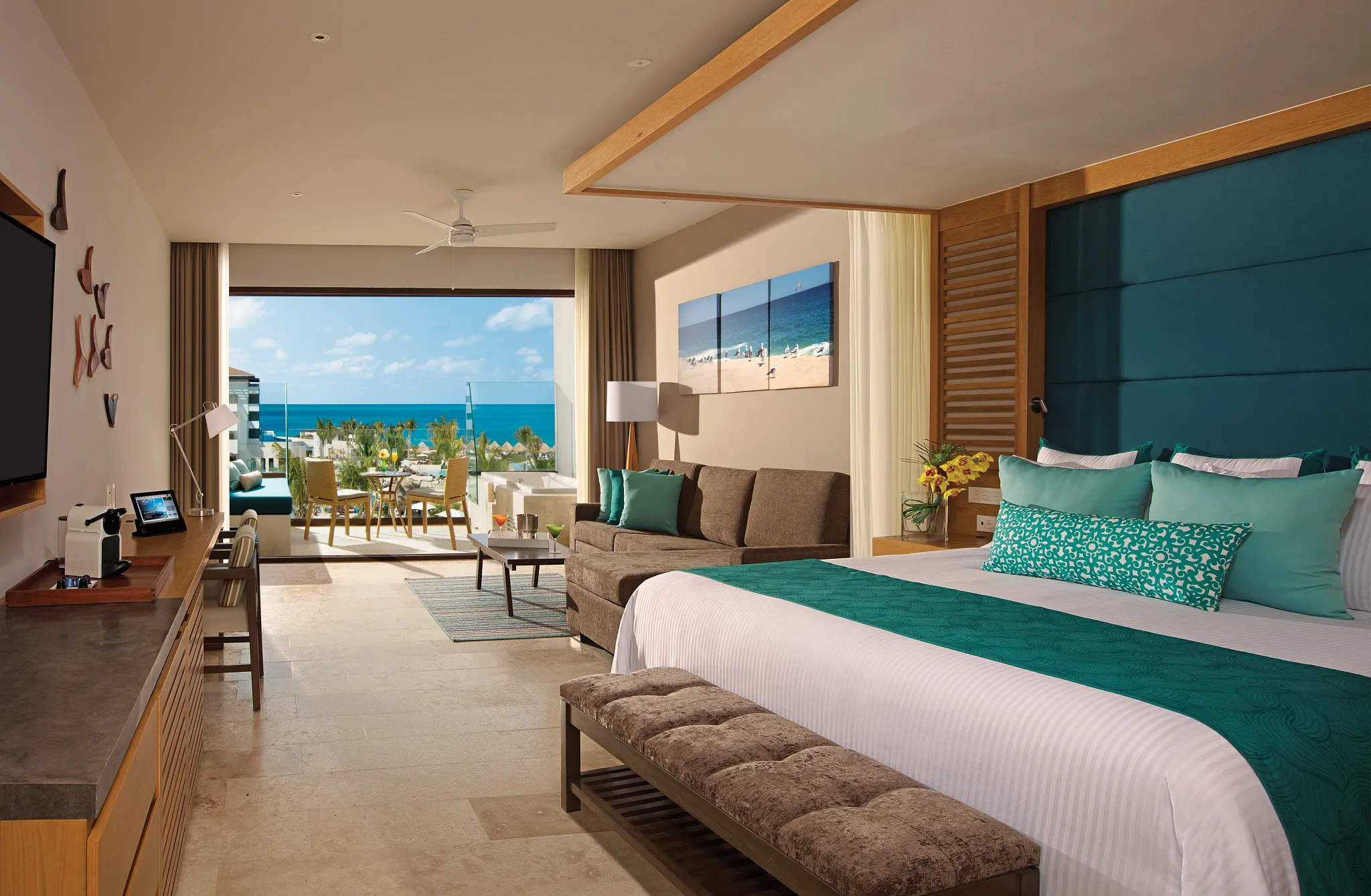 Junior Suite Partial Ocean View with king bed, sofa, and terrace overlooking the ocean at Dreams Playa Mujeres.