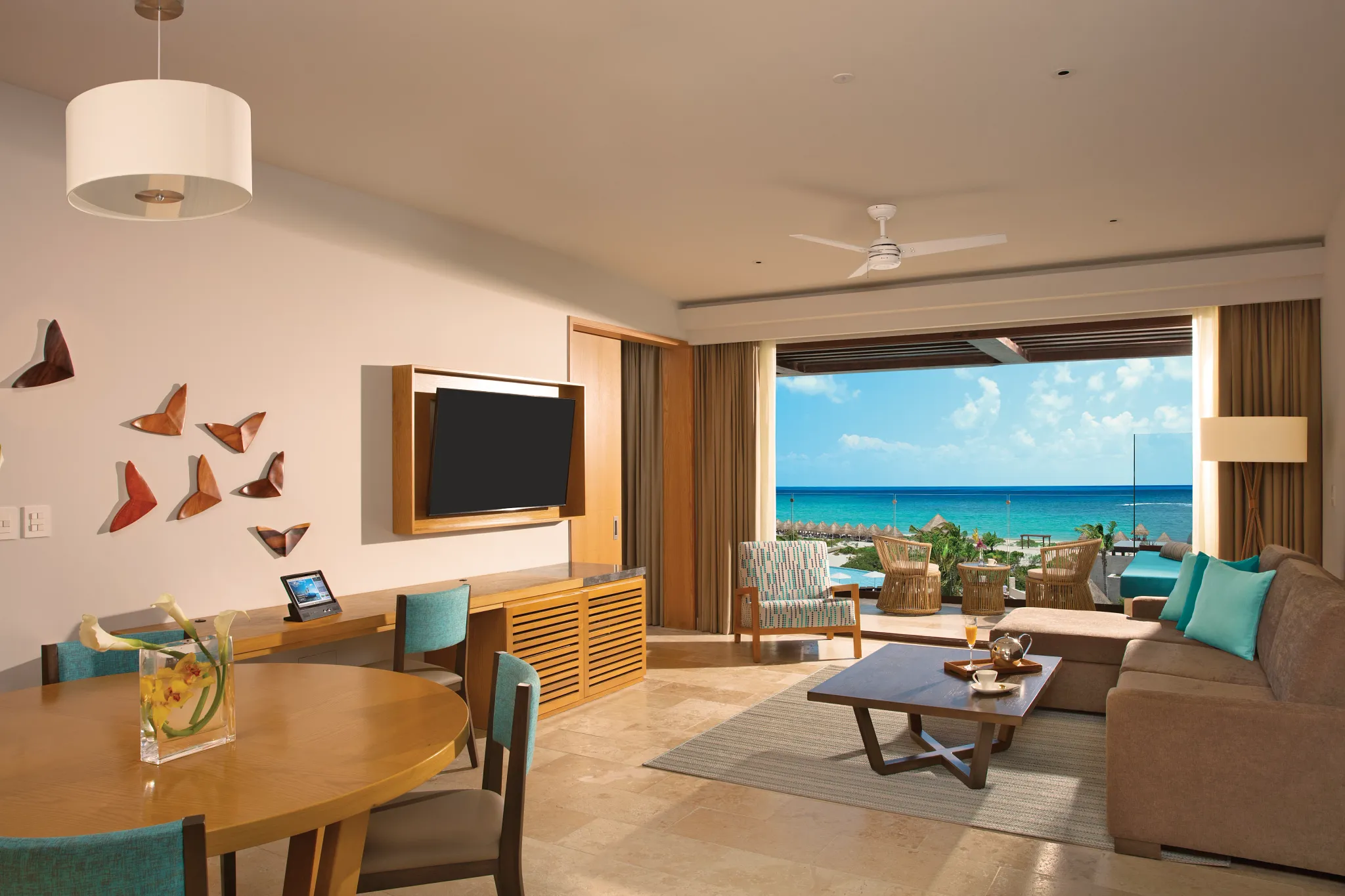 Living room with dining table and ocean view terrace access.