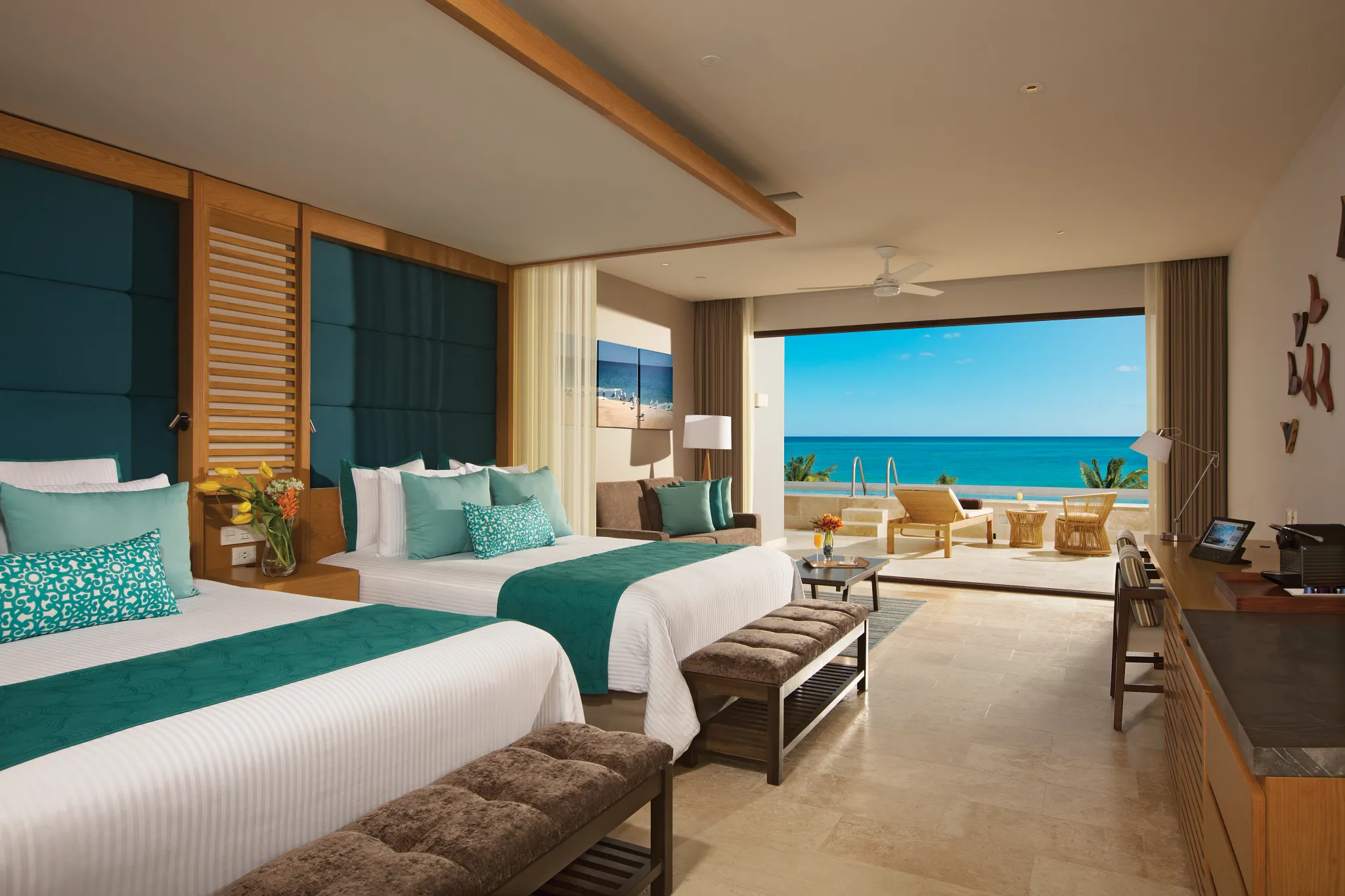 Preferred Club Junior Suite Swim Out Ocean View with two queen beds and oceanfront terrace at Dreams Playa Mujeres.