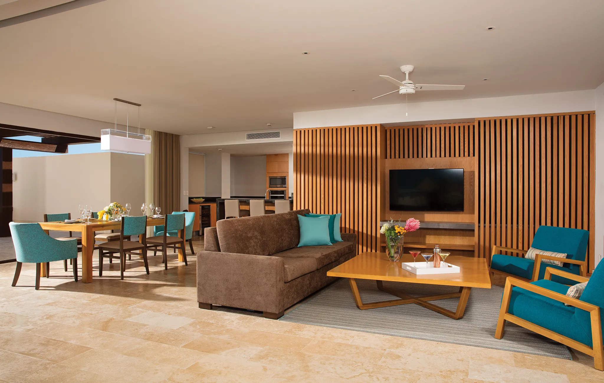 Open living room with sofa, TV, and dining area in large suite.