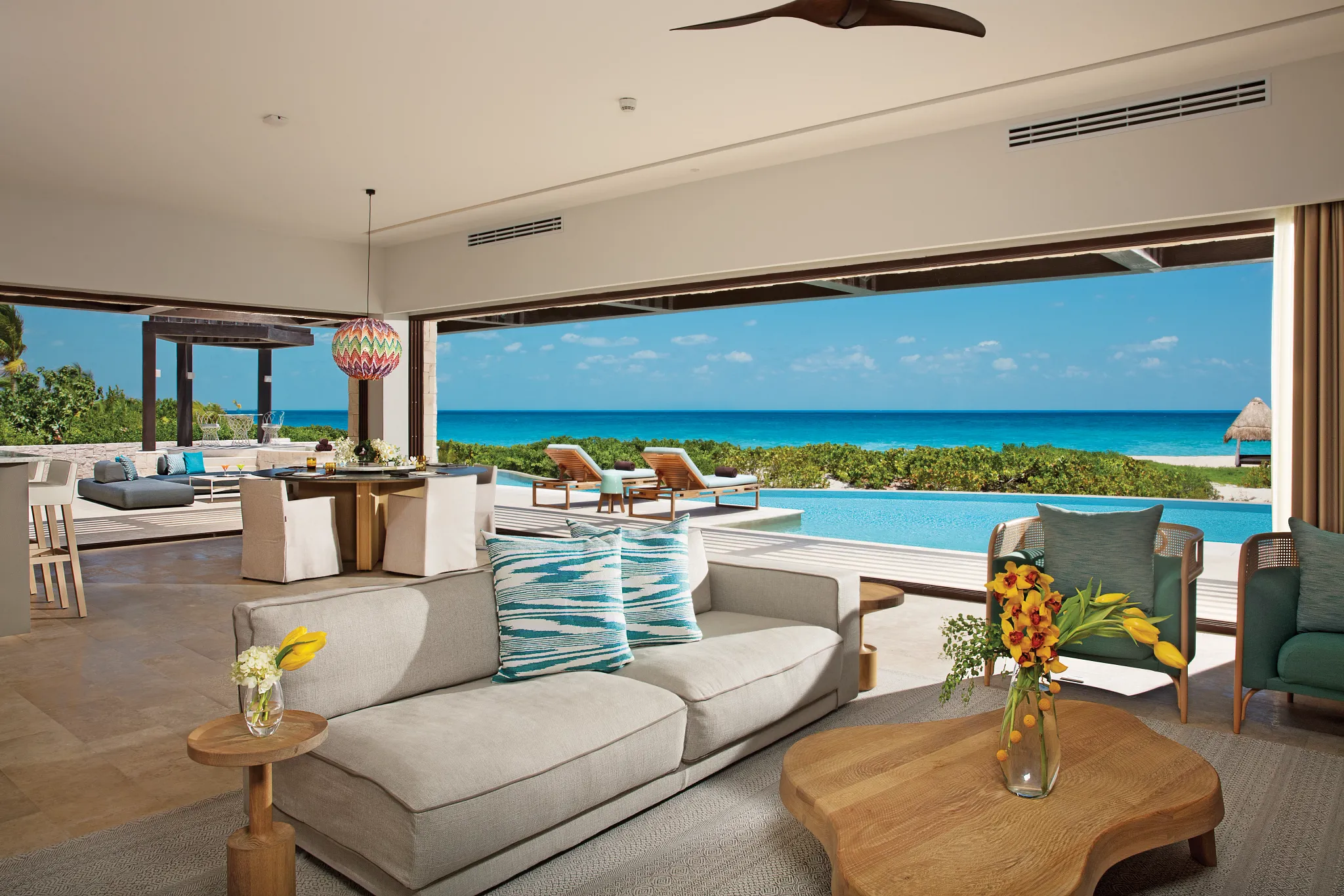 Open living room with ocean view, sofa, and dining area.