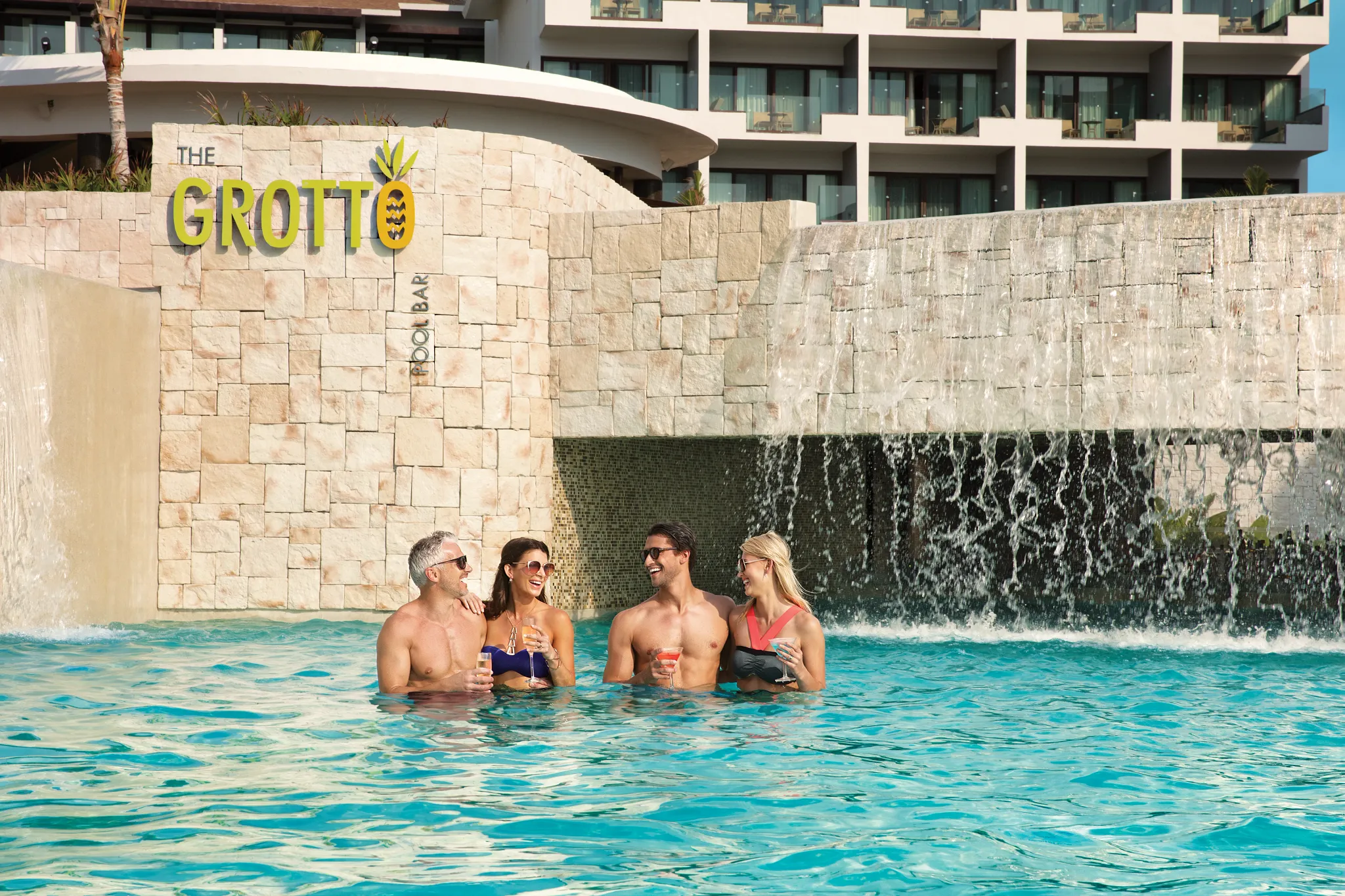 The Grotto poolside bar at Dreams Playa Mujeres Golf & Spa Resort featuring a shaded swim-up bar with refreshing cocktails and a relaxed tropical setting.