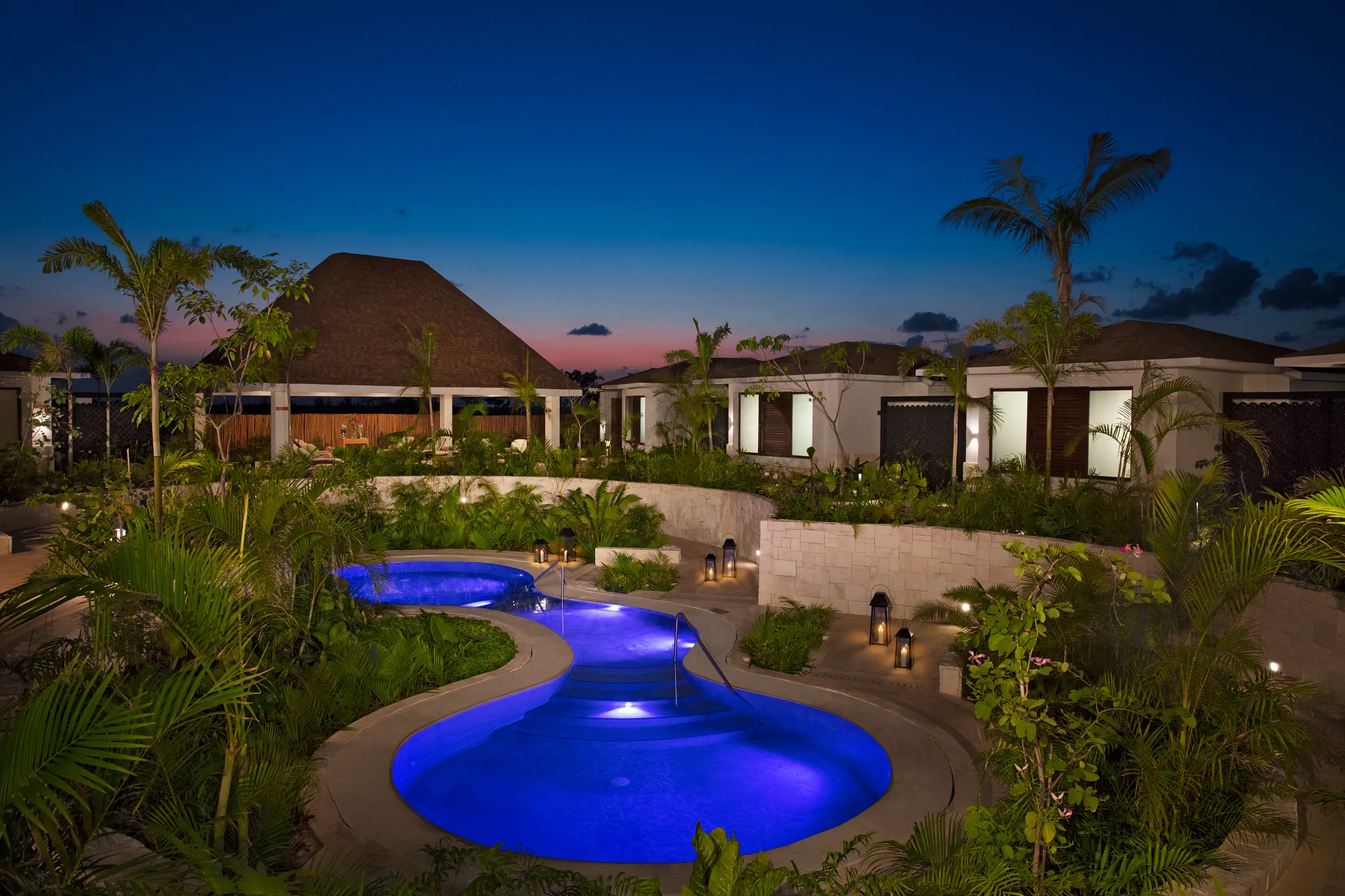 Illuminated hydrotherapy pool at night at Dreams Playa Mujeres Resort spa.